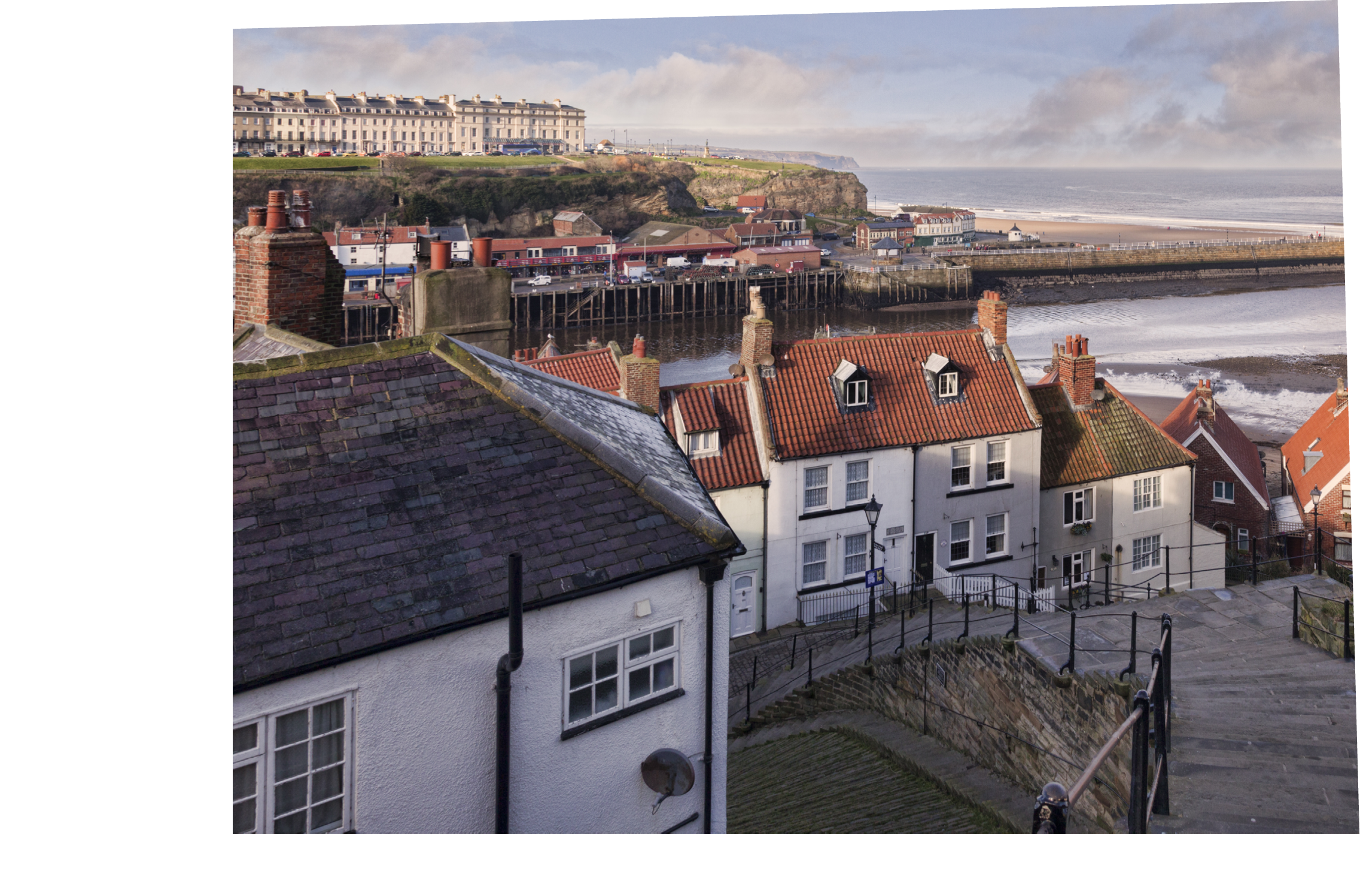The fishing port of Whitby, North Yorkshire, England, UK, on a sunny winter morning, and the famous 199 steps leading from Church Street to the abbey, which were built about 200 years ago 