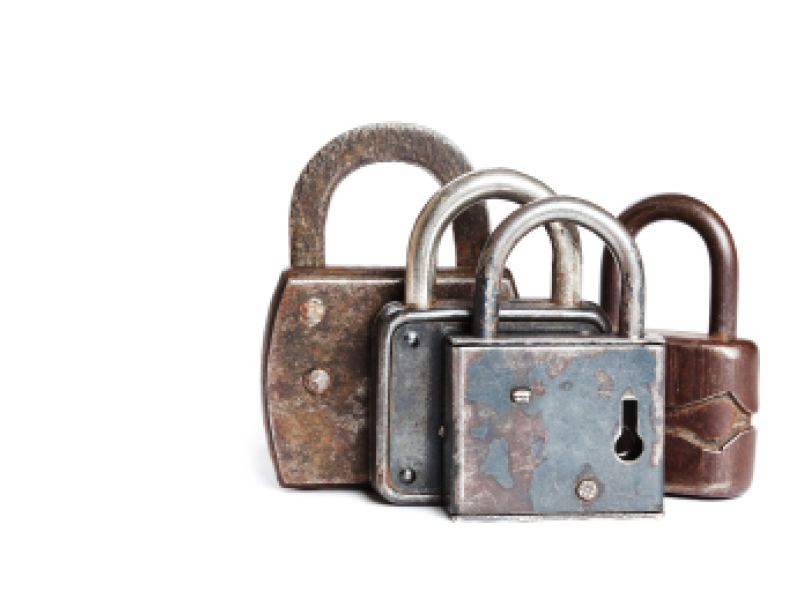 Vintage retro design closed iron padlocks  Aged shabby metallic texture  White background  copy space  macro view 